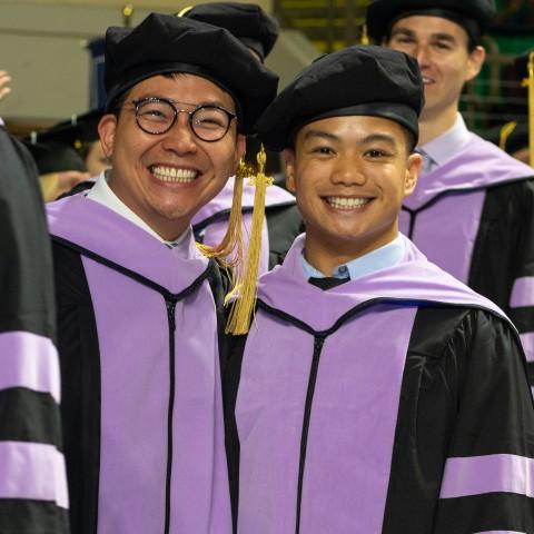 UNE graduates smile for the camera at Commencement